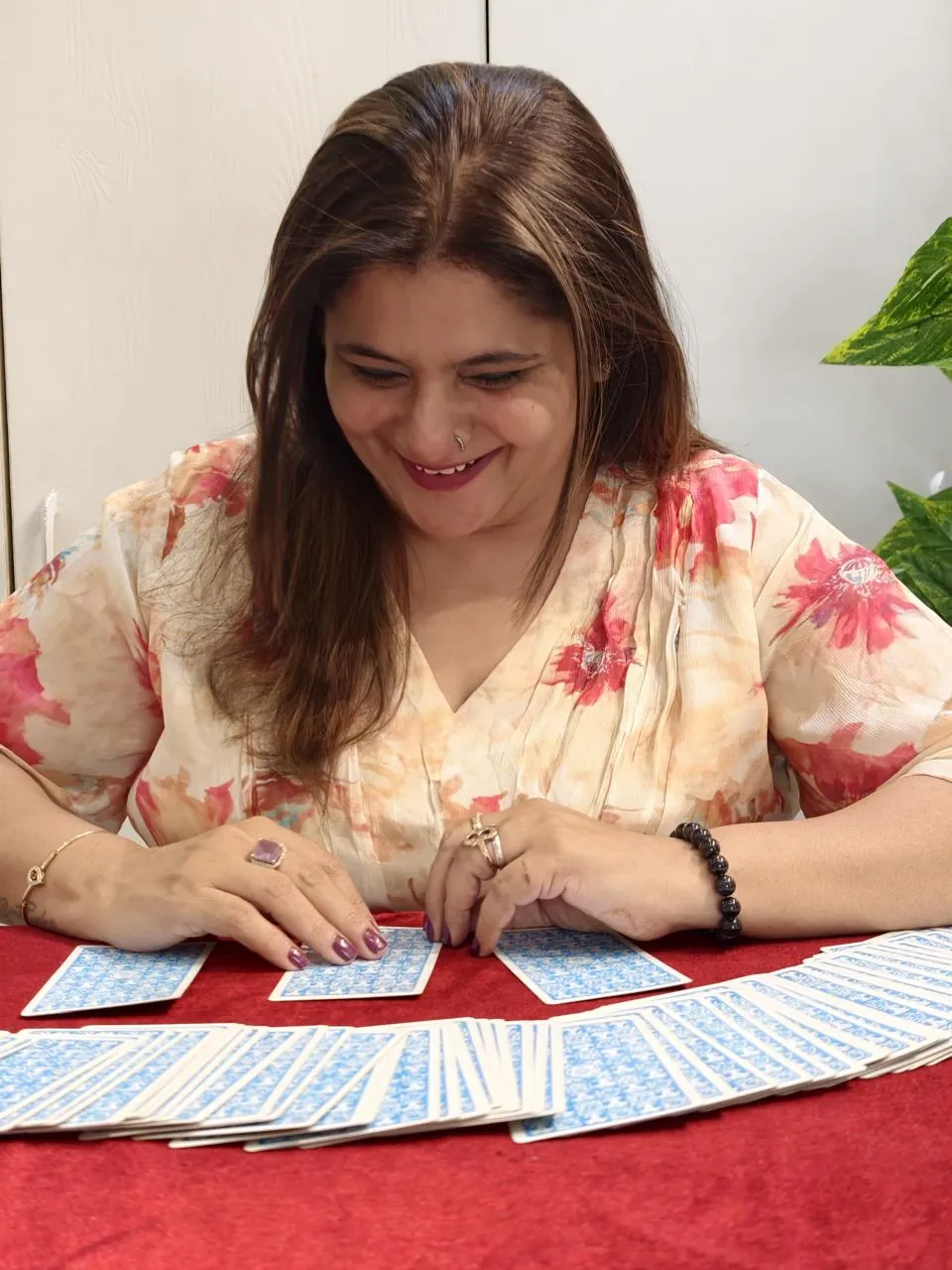 Sapnaa Khemani laughing as she reads three cards drawn from the deck